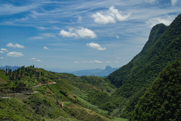Fototapeta premium The road winds through the mountain, revealing a scenic landscape where nature meets the sky, turning every mile of the journey into a breathtaking experience.
