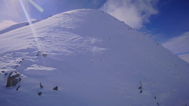 FPV drone surfing a vast, untouched snowy mountain sope.