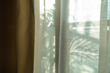 The shadow of the curtain is a burnt leaf pattern.