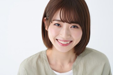 Fototapeta premium Portrait of smiling asian woman with short brown hair and bangs in studio lighting