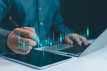 Businessman analyzing stock market candlestick chart on tablet and laptop, representing trading, investment, financial analysis, digital economy, and modern business technology in finance investment