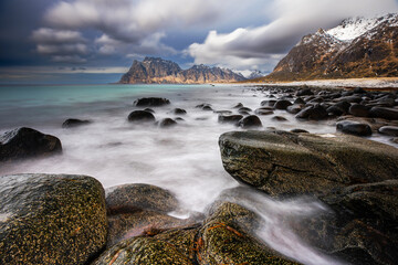 Rocky Beach with Mountain and Cloudy Sky