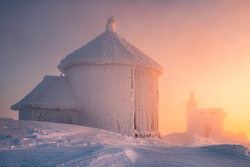Snow-Covered Mountain Hut at Dawn