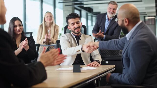 A group of people are sitting around a table in a business setting