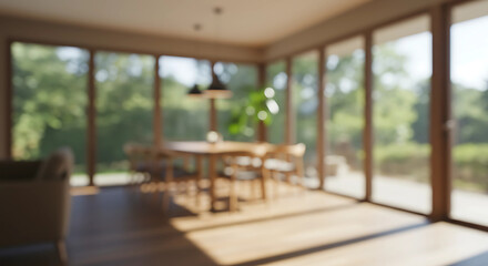 Fototapeta premium blurred Modern dining room with large windows overlooking a lush green forest, bathed in warm sunlight, creating a bright and airy atmosphere for a tranquil meal