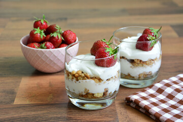 Strawberry Parfaits with Fresh Berries and oat flakes in glasses on wooden texture