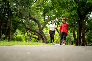 Obraz premium Young couple jogging together in the park, promoting healthy lifestyle and family bonding