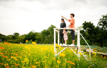 Parents and daughter stand on scaffolding and admire the beautiful flowers