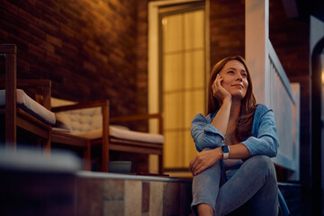 Pensive woman enjoying on porch of her new home.
