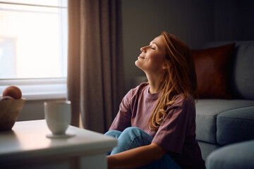 Obraz premium Satisfied woman with eyes closed enjoying at home.