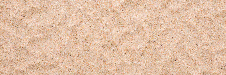 Dry light brown sea sand background. Closeup. Wide banner. Top down view.