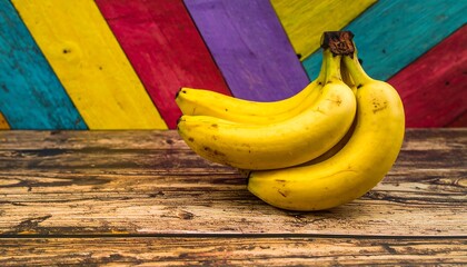Bunch of ripe bananas on rustic wooden table, vibrant colorful background