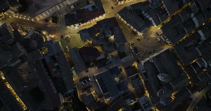 Aerial view of streets, buildings, and a square illuminated by street lights at dusk, creating a beautiful contrast, Sulmona, Abruzzo, Italy.