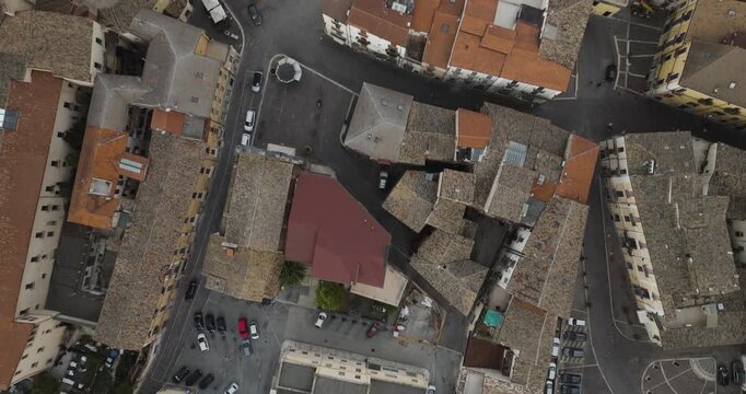Aerial view of the city square shows the brown rooftops and streets of Sulmona, with cars scattered throughout the area, Sulmona, Abruzzo, Italy.