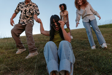 Friends sliding down grassy hill enjoying summer holidays © bernardbodo