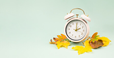Winter time changeover, end of daylight saving time in autumn, alarm clock fall back switch, colorful foliage