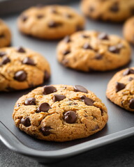 close-up of chocolate chip cookies on baking tray, isolated on white background