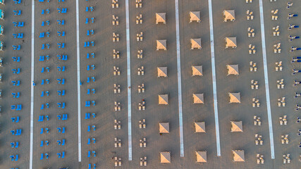 Sun umbrellas and sun loungers on the beach, Tyrrhenian Sea, tourist resort of Viareggio, Italy. View from above