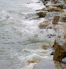 Splashing sea surf hitting rocks on the beach