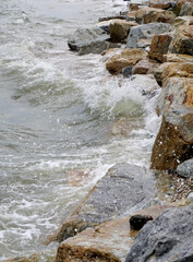 Splashing sea surf hitting rocks on the beach