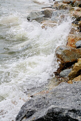 Splashing sea surf hitting rocks on the beach