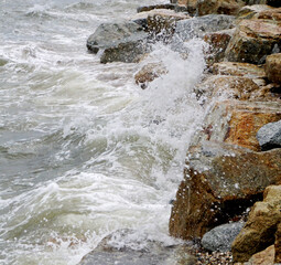 Splashing sea surf hitting rocks on the beach