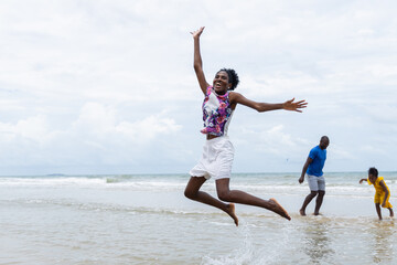 Obraz premium Joyful summer outdoor activities on beach with people enjoying water and playful moments under cloudy sky