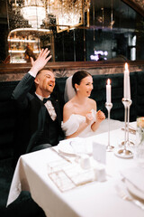 Joyful couple celebrating their wedding in an elegant restaurant during a nighttime reception
