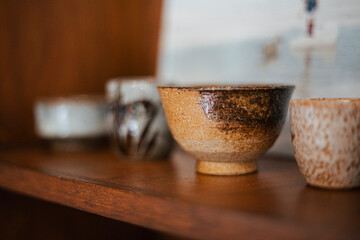 Ceramic pots on a wooden shelf as a decoration item in a row