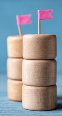 Two miniature wooden towers with pink flags