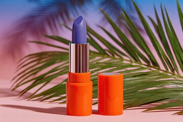 Orange lipstick tube, blue lipstick, palm leaf, pink background