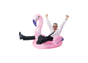 Happy businessman going on vacation and riding an inflatable flamingo