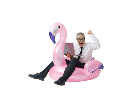 Cheerful businessman riding an inflatable toy and using a laptop