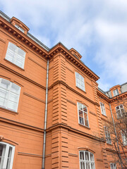 historic orange brick building facade over  blue sky background