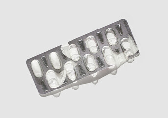 Empty blister pack with silver foil on white background highlighting medication absence.