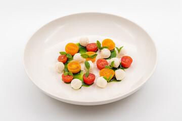 Colorful Caprese salad with cherry tomatoes, mozzarella and fresh basil