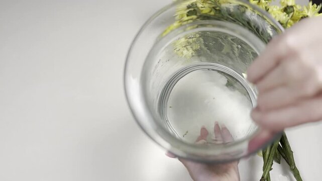 A woman demonstrates a vase with water for a bouquet of flowers, bouquet care, restoration, resuscitation, prolongation of bouquet life, floristry and flower care video concept
