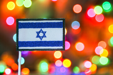 Israel embroidered flag with colorful bokeh fireworks background, symbolizing New Year celebration, national holiday and vibrant festive atmosphere.