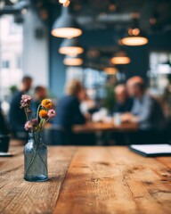 Cafe-style workspace with rustic wooden tabletop in sharp focus and blurred colleagues in the background, ideal for copy space.