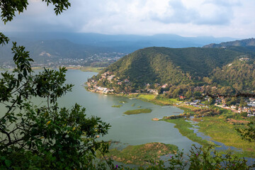 Panoramic view of Valle de Bravo lake in Mexico from La Pena, green mountains surrounding the water under soft daylight, symbolizing travel, tourism, nature and serenity in Latin America