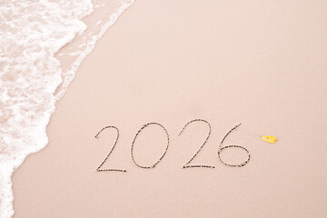 Fototapeta premium 2026 year handwritten with ocean waves on a sandy beach. New Year 2026 concept