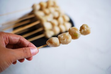 hand holding a pentol cilok 