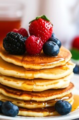 Delicious Fluffy Pancakes Topped with Fresh Berries and Syrup