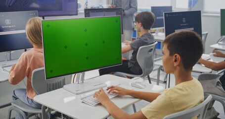 Elementary School Boy Using Computer with Green Screen Template for Educational Content. Young Students Creating Pictures in AI Image Generator During Digital Art Lesson. Interactive STEM Education.