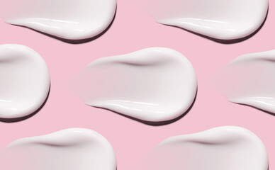 textures pattern of cream smears close-up on pink background