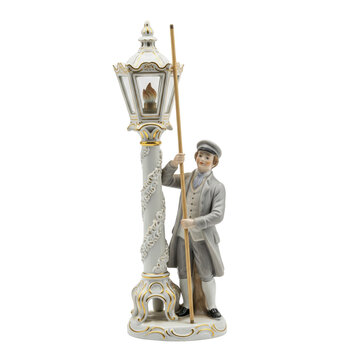 Porcelain figurine of a lamplighter in vintage costume lighting a historical street lamp