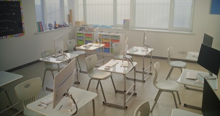 Modern Computer Classroom with White Desks, Chairs and Computer Monitors for Students. Bright Learning Environment for Digital Education, Programming Lessons, Creative 3D Design Projects. Dolly Shot.