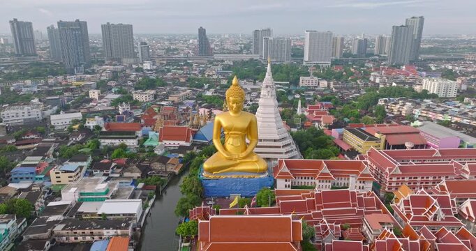 Golden Buddha Statue at Wat Paknam Phasi Charoen Temple in Bangkok Thailand Stands Majestically Amidst Urban Landscape Surrounded by Cityscape
