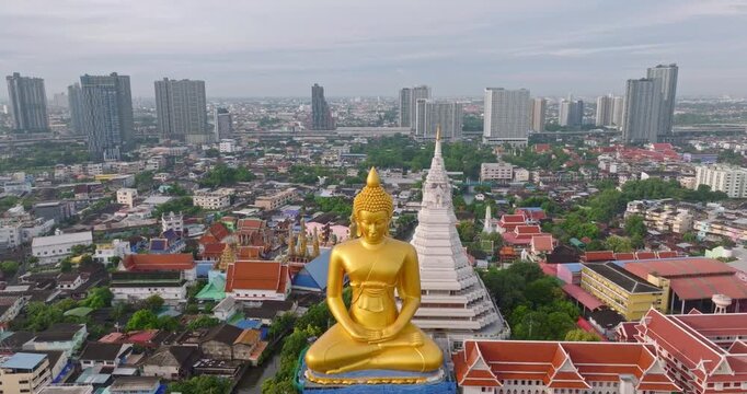 Golden Buddha Statue Overlooking Wat Paknam Phasi Charoen Temple in Bangkok Thailand with Urban Cityscape Backdrop