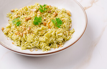 Delicious green rice served in a white bowl with toppings and garnish